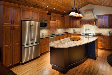 Example of an arts and crafts eat-in kitchen design in Other with an undermount sink, raised-panel cabinets, light wood cabinets, granite countertops, stone tile backsplash and stainless steel appliances