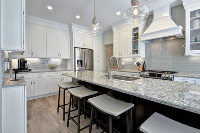 Large trendy l-shaped porcelain tile and brown floor eat-in kitchen photo in Charleston with an undermount sink, shaker cabinets, white cabinets, granite countertops, gray backsplash, glass tile backsplash, stainless steel appliances and an island