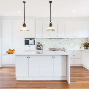Inspiration for a mid-sized beach style u-shaped open plan kitchen in Central Coast with multi-coloured splashback, glass tile splashback, stainless steel appliances and with island.
