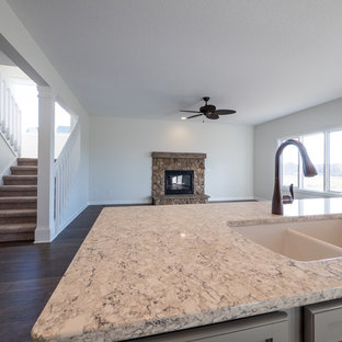 Inspiration for a mid-sized arts and crafts l-shaped open plan kitchen in Other with an integrated sink, flat-panel cabinets, white cabinets, solid surface benchtops, brown splashback, subway tile splashback, stainless steel appliances, dark hardwood floors and with island.