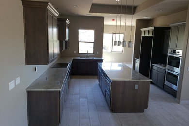 Example of a transitional kitchen design in Phoenix with dark wood cabinets, an island, granite countertops and white countertops