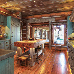 This is an example of a large country u-shaped separate kitchen in Wichita with louvered cabinets, distressed cabinets, zinc benchtops, brown splashback, timber splashback, panelled appliances, medium hardwood floors and with island.