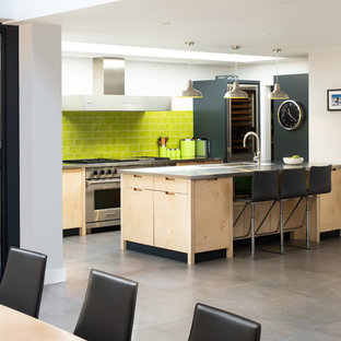 Design ideas for a contemporary galley kitchen/diner in Surrey with flat-panel cabinets, light wood cabinets, green splashback, metro tiled splashback, stainless steel appliances, a breakfast bar, grey floors and grey worktops.