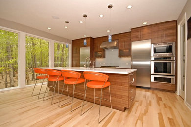 Zweizeilige Moderne Küchenbar mit Küchengeräten aus Edelstahl, flächenbündigen Schrankfronten, hellbraunen Holzschränken und Küchenrückwand in Weiß in Sonstige