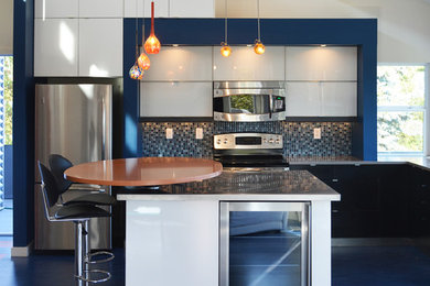 Mid-sized trendy l-shaped linoleum floor and blue floor open concept kitchen photo in Seattle with an undermount sink, flat-panel cabinets, white cabinets, quartz countertops, blue backsplash, mosaic tile backsplash, stainless steel appliances and an island
