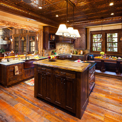 Example of a mountain style eat-in kitchen design in Denver with dark wood cabinets and beige backsplash