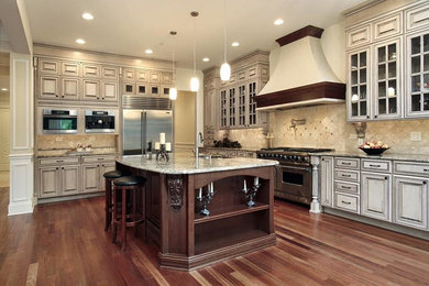 Mid-sized elegant single-wall beige floor eat-in kitchen photo in Boise with flat-panel cabinets, dark wood cabinets, multicolored backsplash, stainless steel appliances and an island