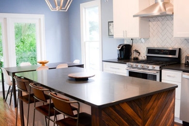 Eat-in kitchen - mid-sized l-shaped dark wood floor and brown floor eat-in kitchen idea in Other with an undermount sink, shaker cabinets, white cabinets, quartz countertops, white backsplash, ceramic backsplash, stainless steel appliances, an island and black countertops