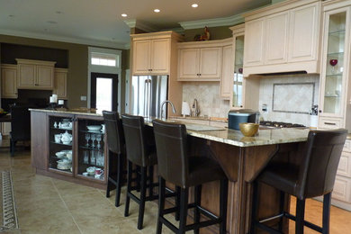 Example of a classic single-wall eat-in kitchen design in Vancouver with raised-panel cabinets, granite countertops, beige backsplash, ceramic backsplash and stainless steel appliances