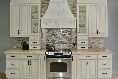 Example of a mid-sized classic porcelain tile enclosed kitchen design in Toronto with an undermount sink, raised-panel cabinets, white cabinets, marble countertops, multicolored backsplash, stainless steel appliances and no island