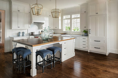 Large farmhouse l-shaped dark wood floor eat-in kitchen photo in Jacksonville with a farmhouse sink, beaded inset cabinets, white cabinets, wood countertops, stainless steel appliances, an island and brown countertops