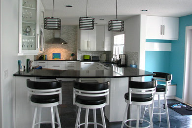 Mid-sized trendy l-shaped eat-in kitchen photo in Edmonton with an undermount sink, flat-panel cabinets, white cabinets, white appliances and a peninsula
