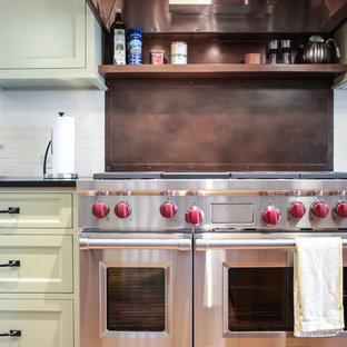 Design ideas for a large country galley open plan kitchen in Minneapolis with a farmhouse sink, recessed-panel cabinets, green cabinets, quartzite benchtops, white splashback, subway tile splashback, panelled appliances, dark hardwood floors and multiple islands.