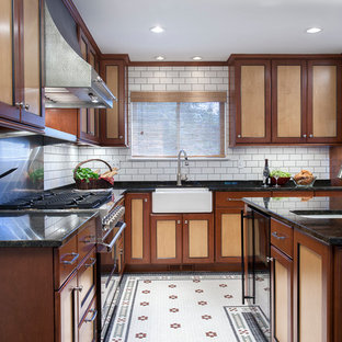 Mid-sized traditional eat-in kitchen designs - Inspiration for a mid-sized timeless l-shaped porcelain tile and multicolored floor eat-in kitchen remodel in DC Metro with a farmhouse sink, shaker cabinets, medium tone wood cabinets, granite countertops, white backsplash, subway tile backsplash, stainless steel appliances and an island
