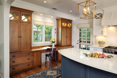 Example of a mid-sized transitional l-shaped light wood floor and brown floor open concept kitchen design in Sacramento with a farmhouse sink, shaker cabinets, white cabinets, quartz countertops, white backsplash, stone slab backsplash, stainless steel appliances, an island and white countertops