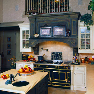 Large victorian l-shaped eat-in kitchen in Other with a farmhouse sink, beaded inset cabinets, white cabinets, limestone benchtops, beige splashback, ceramic splashback, black appliances, porcelain floors and multiple islands.