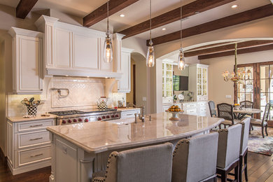Example of a mid-sized french country galley dark wood floor and brown floor eat-in kitchen design in Phoenix with a farmhouse sink, raised-panel cabinets, white cabinets, white backsplash, stainless steel appliances, an island and ceramic backsplash