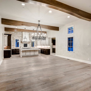 Ispirazione per una grande cucina con lavello stile country, ante con bugna sagomata, ante con finitura invecchiata, top in marmo, paraspruzzi bianco, paraspruzzi con piastrelle in pietra, elettrodomestici in acciaio inossidabile, parquet chiaro, pavimento marrone e top bianco