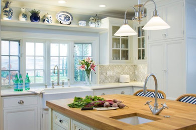 Inspiration for a mid-sized transitional u-shaped medium tone wood floor enclosed kitchen remodel in San Diego with a farmhouse sink, recessed-panel cabinets, distressed cabinets, wood countertops, multicolored backsplash, mosaic tile backsplash, paneled appliances and an island