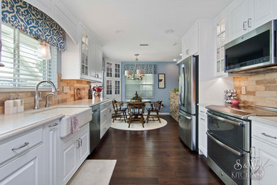 Small classic galley kitchen/diner in Orlando with a belfast sink, raised-panel cabinets, white cabinets, engineered stone countertops, beige splashback, porcelain splashback, stainless steel appliances, dark hardwood flooring, no island and brown floors.