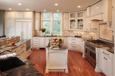 Example of a medium tone wood floor kitchen design in Denver with a single-bowl sink, raised-panel cabinets, beige backsplash, paneled appliances, two islands and white cabinets