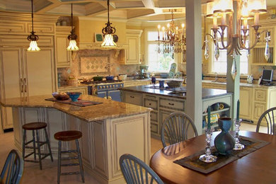 Kitchen - huge eclectic travertine floor kitchen idea in Chicago with raised-panel cabinets, yellow cabinets, granite countertops, ceramic backsplash, colored appliances and two islands