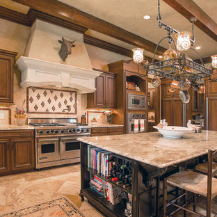 Ejemplo de cocina en L, rural, de tamaño medio, con armarios con paneles con relieve, puertas de armario de madera en tonos medios, salpicadero beige, una isla, electrodomésticos con paneles, fregadero sobremueble, encimera de granito, salpicadero de azulejos de porcelana, suelo de travertino y suelo beige