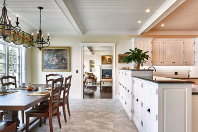 Example of a classic kitchen design in Other with white cabinets, soapstone countertops and white backsplash