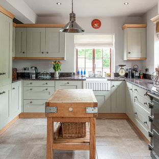 Immagine di una cucina ad U country con lavello stile country, pavimento in pietra calcarea, ante in stile shaker, ante verdi, isola, elettrodomestici colorati e top in granito