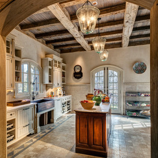 Traditional kitchen designs - Inspiration for a timeless single-wall limestone floor kitchen remodel in New York with medium tone wood cabinets, stainless steel appliances, an island, a farmhouse sink, beaded inset cabinets, quartz countertops, beige backsplash and stone tile backsplash