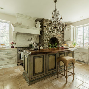 This is an example of a traditional u-shaped kitchen in New York with raised-panel cabinets, white splashback, stainless steel appliances, with island, beige floor, beige benchtop and distressed cabinets.