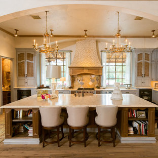 Mediterranean u-shaped open plan kitchen in Houston with a single-bowl sink, blue cabinets, yellow splashback, panelled appliances, raised-panel cabinets and limestone benchtops.