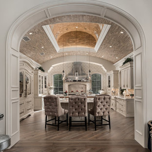 Immagine di un'ampia cucina ad U shabby-chic style chiusa con lavello stile country, ante con bugna sagomata, ante in legno chiaro, top in quarzite, paraspruzzi multicolore, paraspruzzi in gres porcellanato, elettrodomestici in acciaio inossidabile, parquet scuro, 2 o più isole, pavimento marrone e top beige