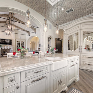 Huge cottage chic u-shaped medium tone wood floor and brown floor enclosed kitchen photo in Phoenix with a farmhouse sink, recessed-panel cabinets, light wood cabinets, quartzite countertops, multicolored backsplash, marble backsplash, stainless steel appliances, two islands and multicolored countertops