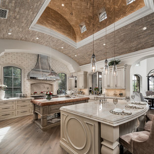 Foto di un'ampia cucina ad U stile shabby chiusa con lavello stile country, ante con riquadro incassato, ante in legno chiaro, top in quarzite, paraspruzzi multicolore, paraspruzzi in marmo, elettrodomestici in acciaio inossidabile, pavimento in legno massello medio, 2 o più isole, pavimento marrone e top multicolore