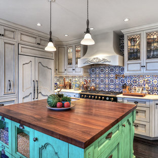 Ispirazione per una cucina mediterranea di medie dimensioni con lavello sottopiano, ante con riquadro incassato, ante bianche, top in legno, paraspruzzi multicolore, elettrodomestici da incasso, paraspruzzi con piastrelle a mosaico, parquet scuro e pavimento marrone