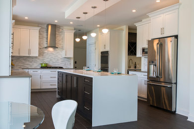 Example of a huge trendy l-shaped porcelain tile open concept kitchen design in Bridgeport with an undermount sink, shaker cabinets, white cabinets, quartz countertops, white backsplash, mosaic tile backsplash, stainless steel appliances and an island