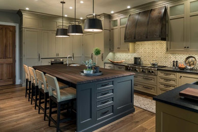 Huge elegant u-shaped medium tone wood floor and brown floor enclosed kitchen photo in Chicago with a farmhouse sink, beaded inset cabinets, gray cabinets, granite countertops, multicolored backsplash, porcelain backsplash, paneled appliances and an island