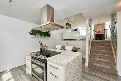 Eat-in kitchen - mid-sized modern u-shaped ceramic tile and gray floor eat-in kitchen idea in Vancouver with a double-bowl sink, flat-panel cabinets, white cabinets, marble countertops, gray backsplash, glass tile backsplash, stainless steel appliances and an island