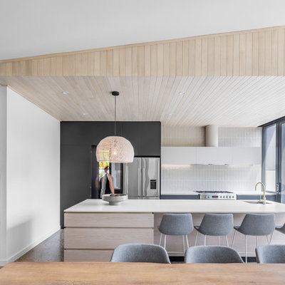 Inspiration for a contemporary galley concrete floor and gray floor eat-in kitchen remodel in Adelaide with an undermount sink, flat-panel cabinets, light wood cabinets, white backsplash, stainless steel appliances, an island and white countertops