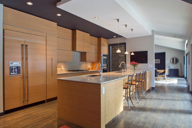 Foto på ett mellanstort funkis kök, med släta luckor, skåp i mellenmörkt trä, grått stänkskydd, integrerade vitvaror, en enkel diskho, stänkskydd i keramik, mellanmörkt trägolv, en halv köksö, brunt golv och bänkskiva i kvartsit