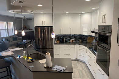 Exempel på ett mellanstort modernt grå grått kök, med en undermonterad diskho, släta luckor, vita skåp, bänkskiva i kvartsit, flerfärgad stänkskydd, stänkskydd i stickkakel, rostfria vitvaror, klinkergolv i porslin, en halv köksö och grått golv