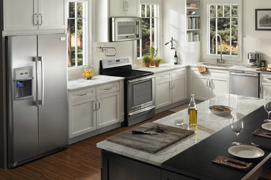 Kitchen - mid-sized traditional light wood floor kitchen idea in Other with a double-bowl sink, raised-panel cabinets, medium tone wood cabinets, granite countertops, beige backsplash, wood backsplash, stainless steel appliances and no island