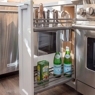 Mid-sized modern eat-in kitchen inspiration - Inspiration for a mid-sized modern medium tone wood floor and brown floor eat-in kitchen remodel in San Francisco with an undermount sink, white cabinets, quartz countertops, white backsplash, glass tile backsplash, stainless steel appliances, no island and white countertops
