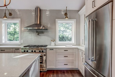 Inspiration for a mid-sized transitional l-shaped medium tone wood floor eat-in kitchen remodel in Toronto with an undermount sink, shaker cabinets, gray cabinets, quartz countertops, gray backsplash, porcelain backsplash, stainless steel appliances and an island