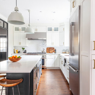 Ispirazione per una cucina a L costiera di medie dimensioni e chiusa con lavello sottopiano, ante in stile shaker, ante bianche, top in quarzo composito, paraspruzzi bianco, paraspruzzi con piastrelle in ceramica, elettrodomestici in acciaio inossidabile, pavimento in legno massello medio, isola, pavimento marrone e top bianco