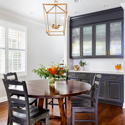 Eat-in kitchen - mid-sized coastal l-shaped medium tone wood floor and brown floor eat-in kitchen idea in Chicago with an undermount sink, shaker cabinets, white cabinets, quartz countertops, white backsplash, ceramic backsplash, stainless steel appliances, an island and white countertops