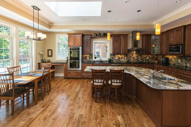 Inspiration for a timeless l-shaped medium tone wood floor eat-in kitchen remodel in St Louis with an undermount sink, raised-panel cabinets, dark wood cabinets, granite countertops, brown backsplash, porcelain backsplash, stainless steel appliances and an island