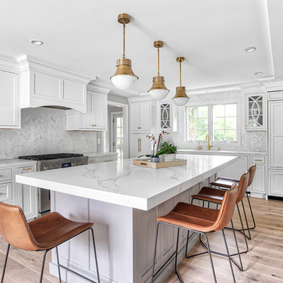 Inspiration for a large transitional l-shaped light wood floor and beige floor eat-in kitchen remodel in New York with paneled appliances, an island, an undermount sink, white cabinets, quartz countertops, white backsplash, mosaic tile backsplash, white countertops and shaker cabinets