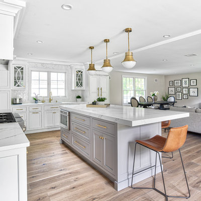 Open concept kitchen - large transitional l-shaped open concept kitchen idea in New York with an undermount sink, beaded inset cabinets, white cabinets, quartz countertops, white backsplash, mosaic tile backsplash, paneled appliances, an island and white countertops